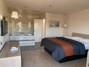 a bedroom with a bed and a bathroom with a tub at Diamond Inn in North Hills