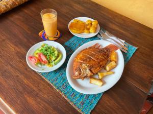 Ein Tisch mit zwei Tellern Essen, darunter Fisch und Gemüse in der Unterkunft Hotel La Mana Nobsa in Nobsa
