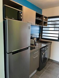 a kitchen with a stainless steel refrigerator and a dishwasher at Studio d affaires Piscine rooftop in Cayenne