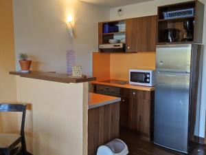 uma pequena cozinha com um frigorífico e um balcão em Appartement Jausiers, 3 pièces, 6 personnes - FR-1-165B-3 em Jausiers