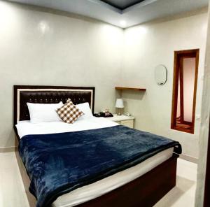 a bedroom with a large bed with a blue blanket at Guest house Cemara in Pasuruan