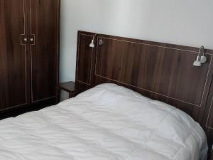 Bett mit einem Kopfteil aus Holz in einem Schlafzimmer in der Unterkunft Appartement Jausiers, 3 pièces, 6 personnes - FR-1-165B-20 in Jausiers