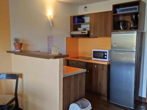 a small kitchen with a refrigerator and a counter at Appartement Jausiers, 3 pièces, 6 personnes - FR-1-165B-21 in Jausiers