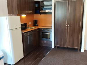 eine Küche mit einem weißen Kühlschrank und Holzschränken in der Unterkunft Appartement Jausiers, 3 pièces, 6 personnes - FR-1-165B-28 in Jausiers