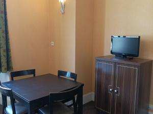 a dining room with a table and a television on a cabinet at Appartement T3 dans Château avec Piscine et Sauna à Jausiers - 6 pers, 55m² - FR-1-165B-32 in Jausiers