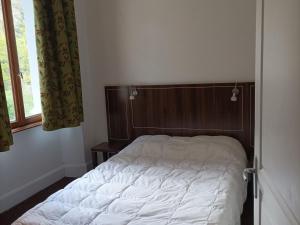 1 dormitorio con 1 cama con cabecero de madera y ventana en Appartement Jausiers, 3 pièces, 6 personnes - FR-1-165B-32, en Jausiers