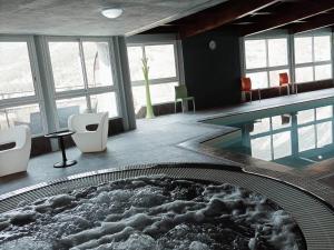 Pokój z basenem z krzesłami i stołem w obiekcie Studio cosy avec piscine, WiFi et parking - FR-1-165B-41 w mieście Jausiers