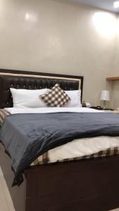 a large bed with a black headboard and white pillows at Guest house Cemara in Pasuruan
