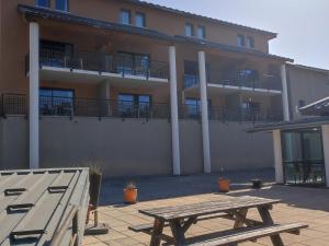 a wooden picnic table in front of a building at Studio Jausiers, 1 pièce, 4 personnes - FR-1-165B-48 in Jausiers