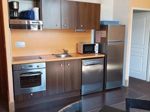 a kitchen with a stainless steel refrigerator and a sink at Appartement Jausiers, 2 pièces, 4 personnes - FR-1-165B-50 in Jausiers