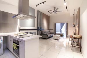 M Suites Jalan Ampang by Plush في كوالالمبور: مطبخ وغرفة معيشة مع فرن علوي وموقد