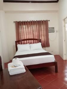 una camera da letto con un letto, un tavolo e una finestra di Medellin Seaview Inn a Medellin