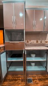 a kitchen with brown cabinets and a counter top at Reef Al Qassim Hotel Apartments in Buraydah