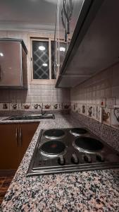 a kitchen with a stove and a counter top at Reef Al Qassim Hotel Apartments in Buraydah