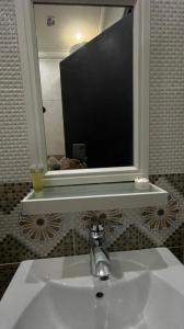 a bathroom sink with a tv above a mirror at Reef Al Qassim Hotel Apartments in Buraydah