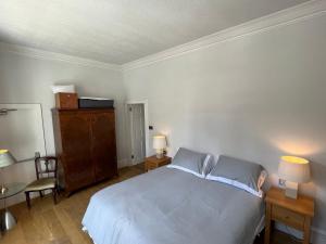 1 dormitorio con 1 cama, 2 lámparas y 1 silla en Central 1-Bed Apartment in Inverness Sleeps 4, en Inverness