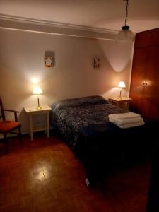 1 dormitorio con 1 cama y 2 mesas con lámparas en Hermoso dpto centrico externo c/ balcones en Córdoba