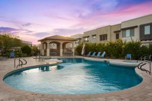 a swimming pool in a yard with chairs and a building at Pinnacle Paradise in Scottsdale
