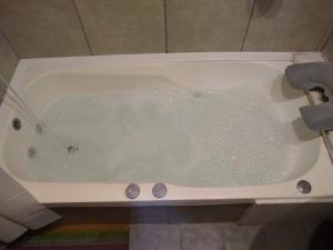 a bath tub filled with water in a bathroom at cabaña la casa del arbol in Tandil +26 photos