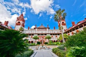 un gran edificio con una palmera delante en Cozy & Quiet Two Bedroom Condo In The Heart Of Historic St. Augustine, en St. Augustine