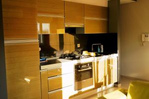 cocina con armarios de madera y horno con fogones en Apartment Zaralux, en Zadar