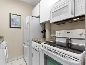 uma cozinha com electrodomésticos brancos e armários brancos em 1 Bedroom at Madeira Beach Yacht Club 165C em St. Pete Beach