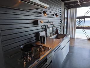 a kitchen with a counter with a sink and a stove at Yokosuka Sky Grey -横須賀- in Yokosuka