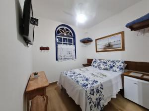 a bedroom with a bed and a tv in it at Pousada do Vovô Luiz in Conservatória