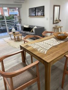 una mesa de madera y sillas en la sala de estar. en Excelente departamento en Puerto Madero en Buenos Aires