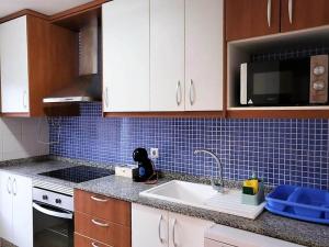 een keuken met een wastafel en blauwe tegels op de muur bij Apartment in Spain near Sandy Beach in Vera