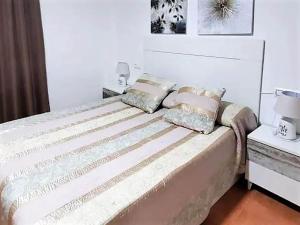 ein Bett mit zwei Kissen darauf in einem Schlafzimmer in der Unterkunft Duplex in Urb Naturista near Beach & Pool in Playas de Vera + 33 Fotos