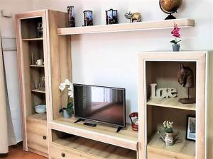 ein Fernseher in einem Bücherregal in einem Wohnzimmer in der Unterkunft Duplex in Urb Naturista near Beach & Pool in Playas de Vera