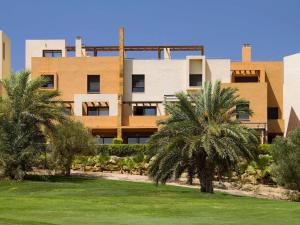 Un edificio con palmeras delante. en Belvilla by OYO Valle del Este las Yucas, en El Esparragal