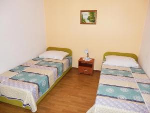 two beds in a small room with a table at Apartment MARA in Šilo