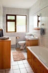 a bathroom with a tub and a toilet and a sink at Shannonview Self Catering in Ballinderry
