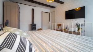 1 dormitorio con 1 cama y TV en la pared en Mala kuća en Vele Drage