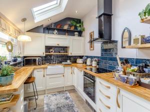 a kitchen with white cabinets and wooden counter tops at 4 Ford Street in Durham