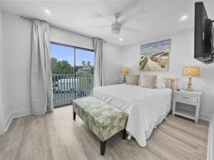 a white bedroom with a bed and a balcony at Seacrest - 6 Townhouse in Watersound Beach