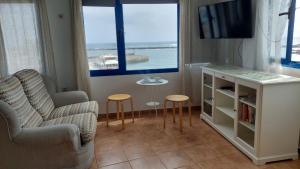 salon z telewizorem, kanapą i krzesłem w obiekcie APARTAMENTO ROQUE DEL ESTE w mieście Orzola +3 zdjęcia
