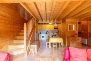 eine Küche und ein Esszimmer in einem Blockhaus in der Unterkunft Quiet apartment near the slopes in La Clusaz