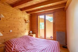 1 dormitorio con 1 cama en una habitación de madera en Quiet apartment near the slopes en La Clusaz