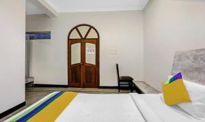 a bedroom with a bed and a wooden door at Itsy By Treebo - Anurag Inn in Mysore