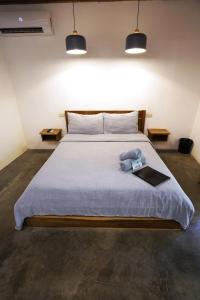 ein Schlafzimmer mit einem Bett mit einem Buch und zwei Lichtern in der Unterkunft Fisheye The Rooms - Room 2 in El Nido