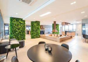 a living wall in a lobby with a table and chairs at Studios Sampa - Moema Cotovia in Sao Paulo