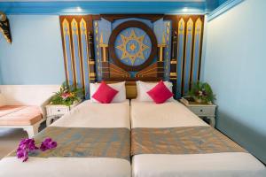 a bedroom with two beds with pink pillows at Ayodhaya Palace Beach Resort-Family run -SHA Plus certified in Ao Nang Beach