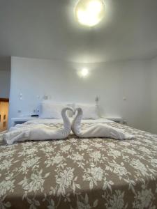 dos cisnes están sentados en una cama en Alamana's House - Ideal for couples, en Ano Mera