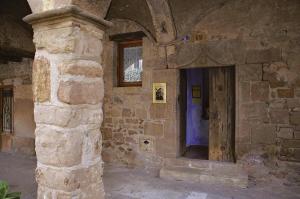 un edificio de piedra con una puerta de madera en Apartaments Plaça Major, en Santa Pau