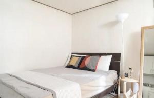 een witte slaapkamer met een bed en een spiegel bij Seoul Central Namsan Studio #103 in Seoul