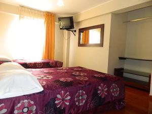 a bedroom with a purple bed and a window at Hostal Barranco in Lima