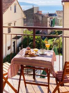 einen Tisch mit einem Teller Essen auf dem Balkon in der Unterkunft Apartments Mimoza Komiza in Komiža